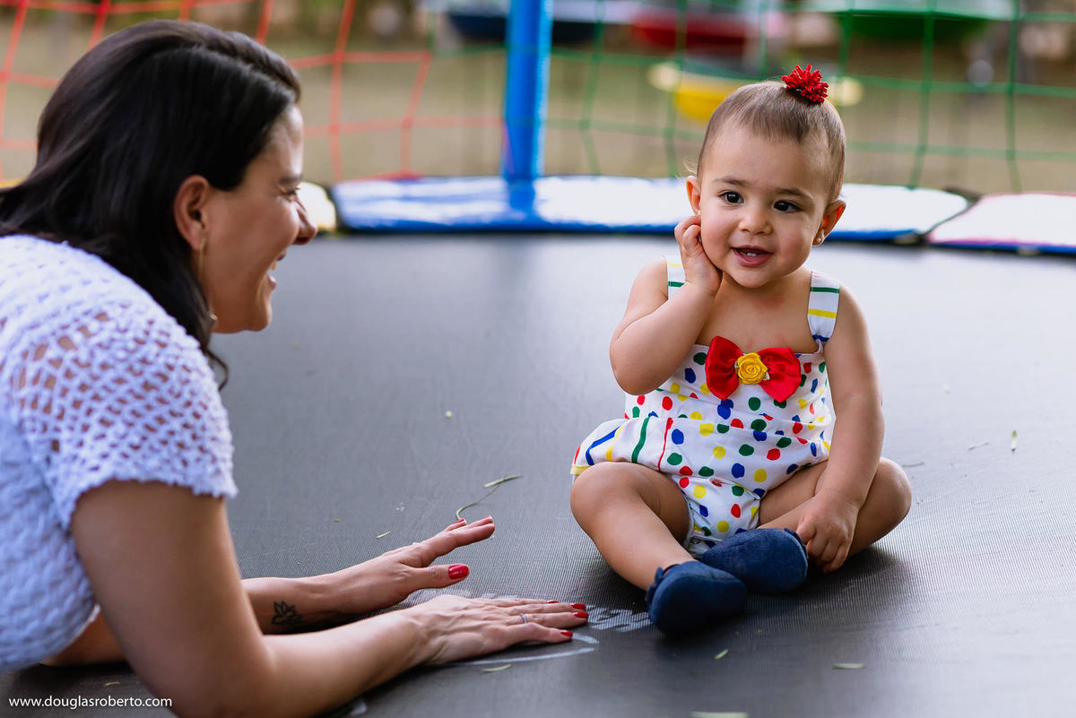 mãe brincando no pula pula com filha