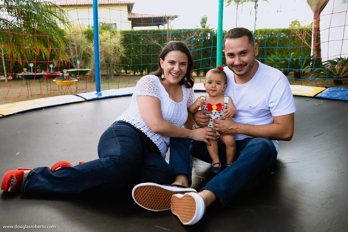 pais brincando com a filha no pula pula