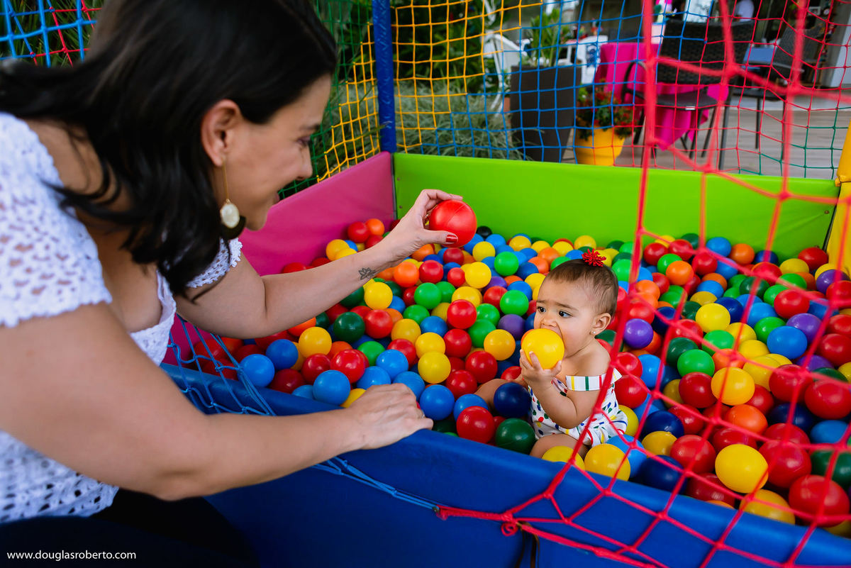 mãe brincando com filha na piscina de bolinhas