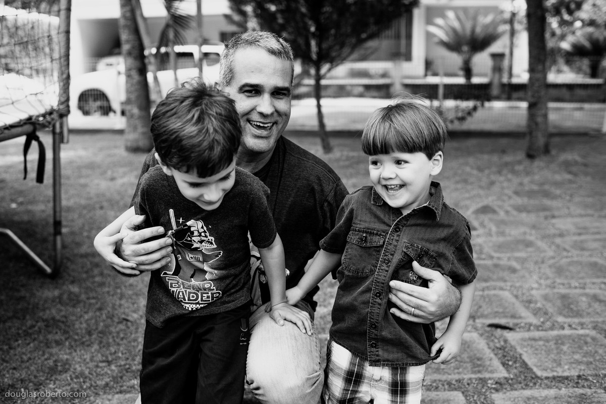 pai abraçando o filho e o sobrinho