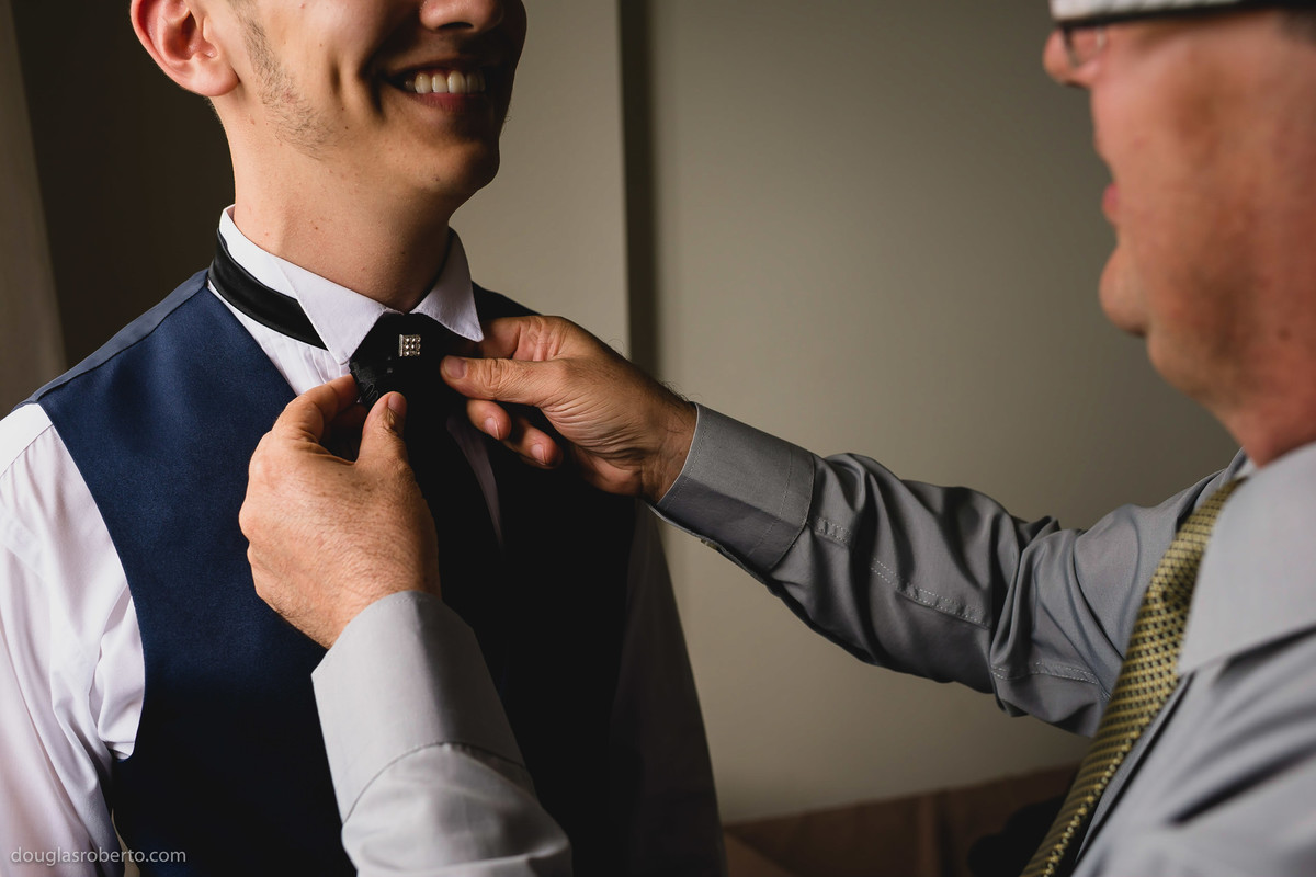 pai arrumando o noivo para o casamento