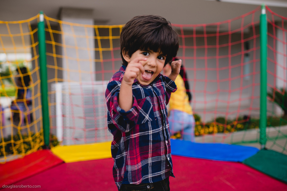 menio engraçado pulando no pula pula