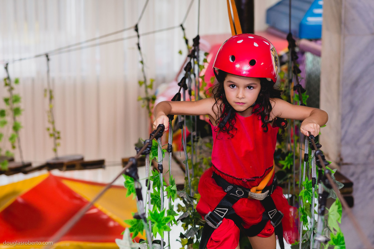 criança fazendo arborismo