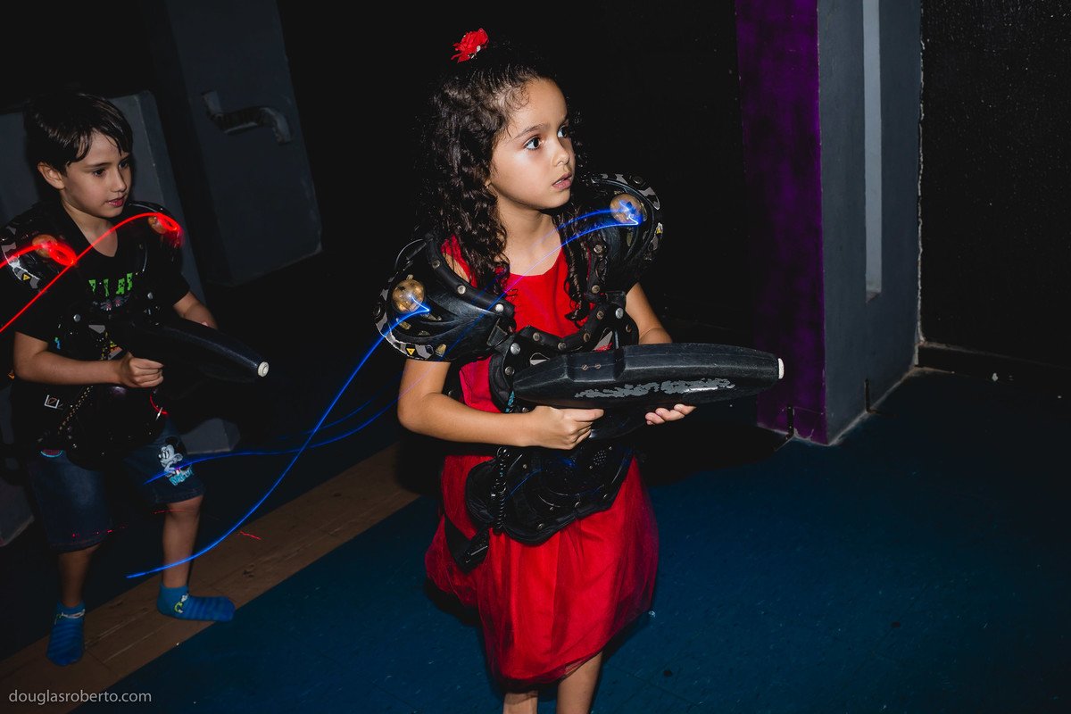 menina briando de atirar com arma de brinquedo