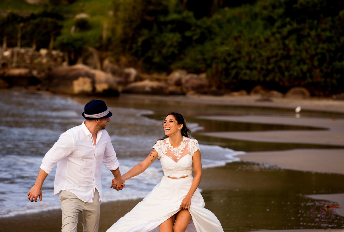 casal de noivos correndo na praia floripa sc