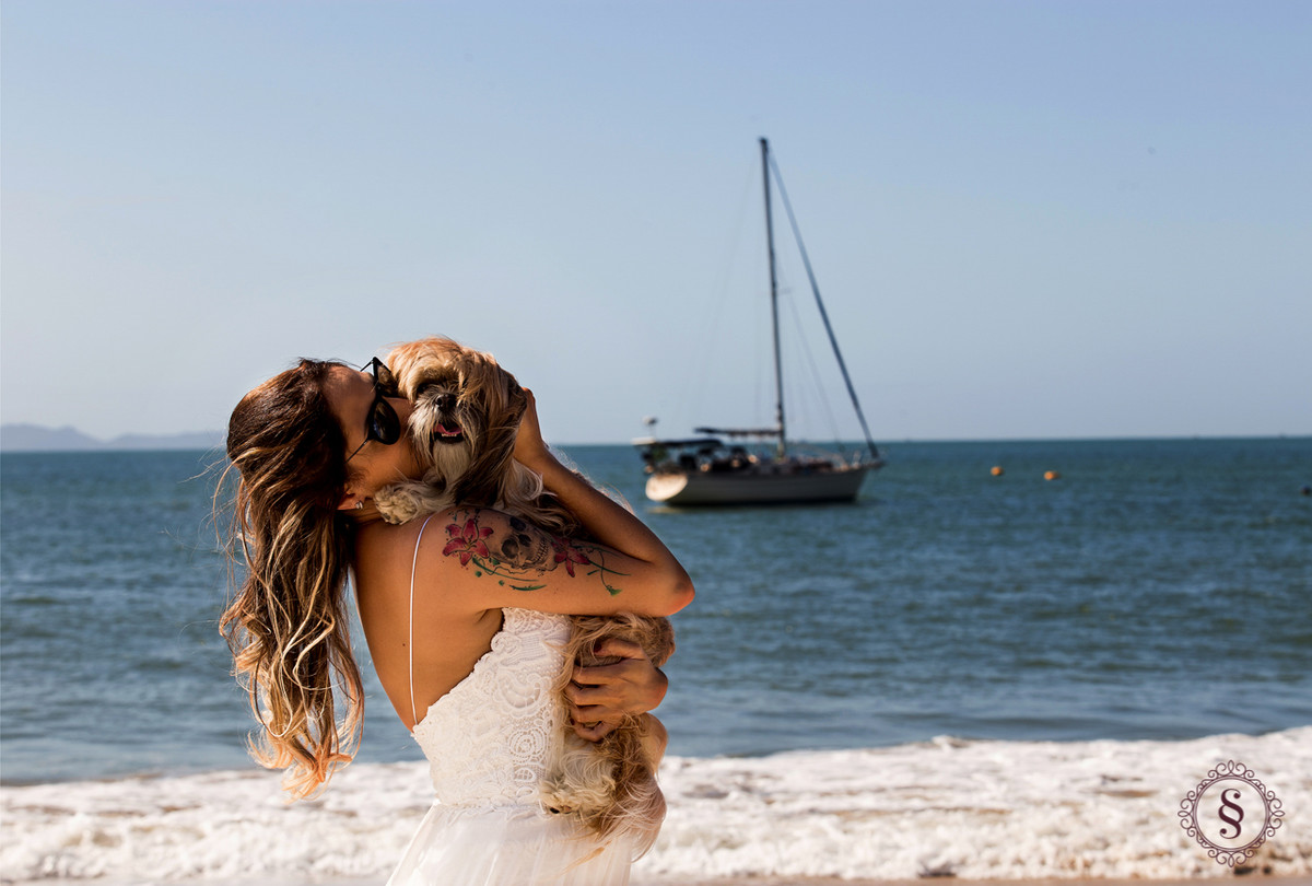 noiva com cachorro no colo na praia