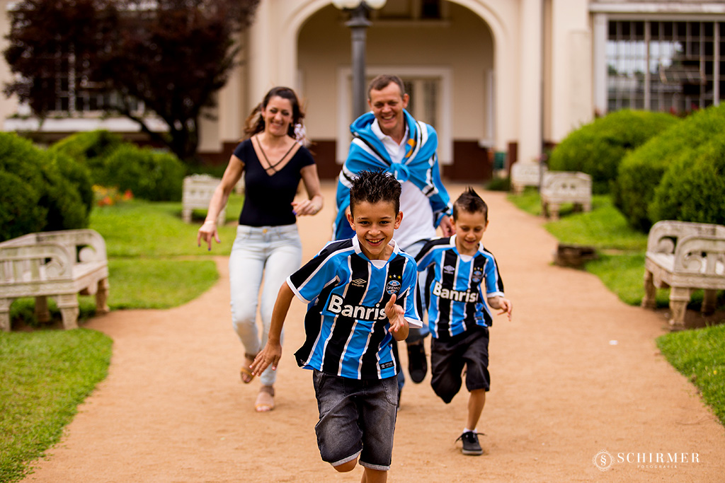 corrida no ensaio de casal entre pais e filhos em frente a casa