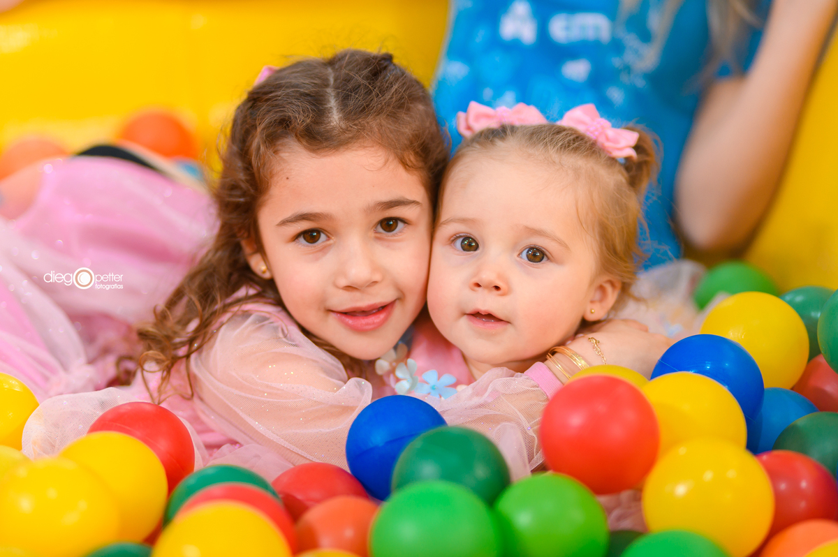 foto com irmãs no aniversário de 1º aninho na piscina de bolinha