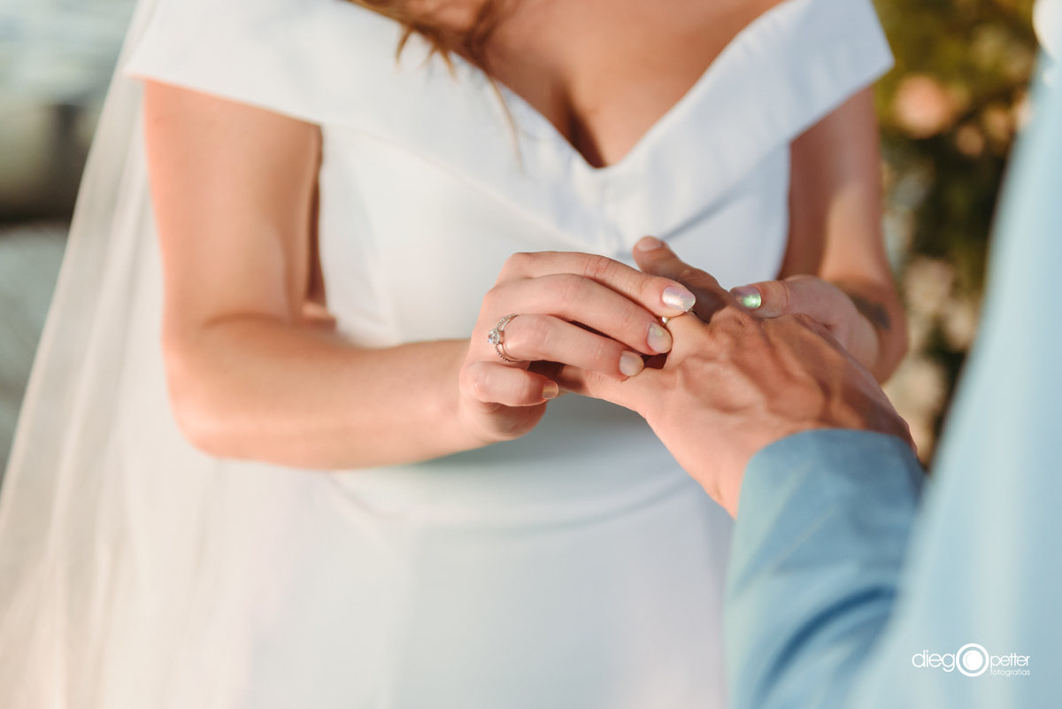 noiva colocando aliança no noivo