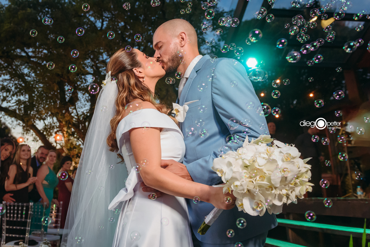 saída dos noivos no dia do casamento com bolhas de sabão