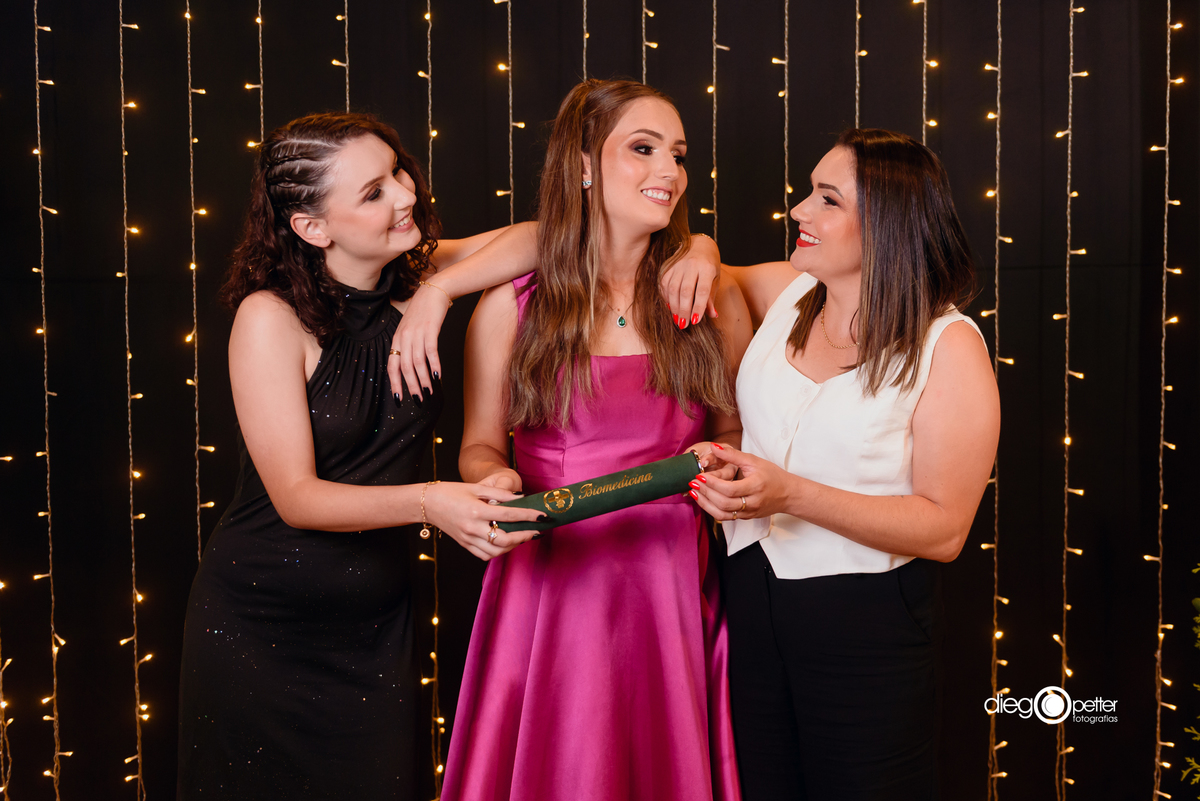 formanda com as irmãs na recepção de formatura