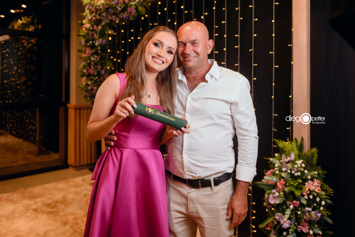 formanda com o pai no dia da formatura
