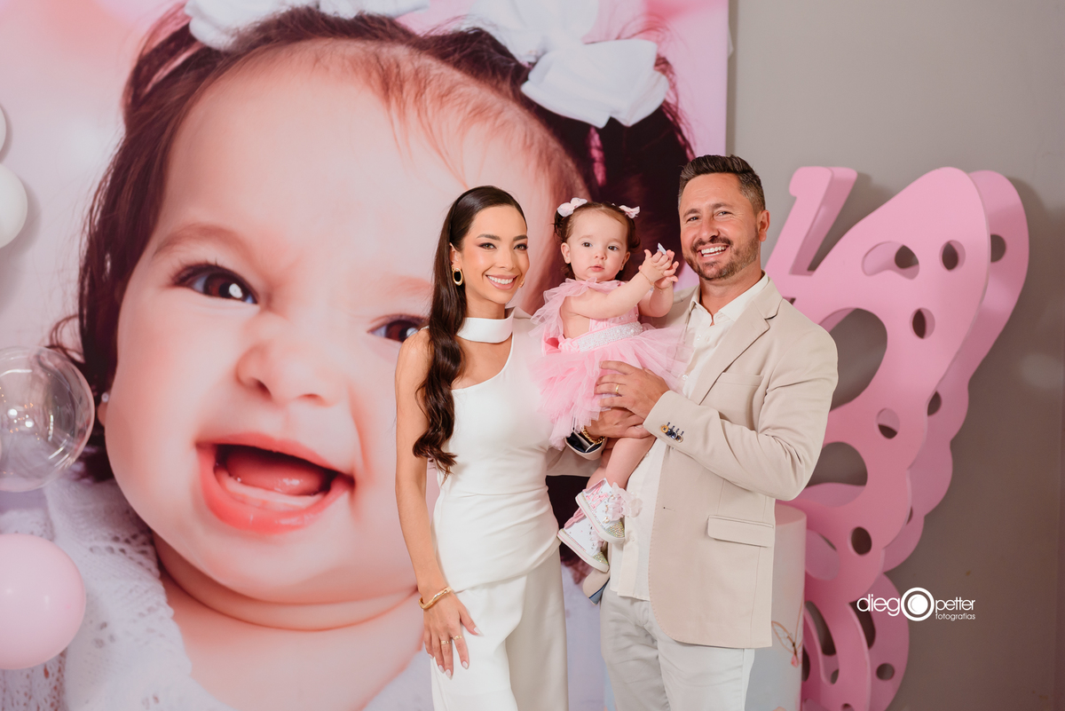 pais posando para foto com a filha de 1 ano