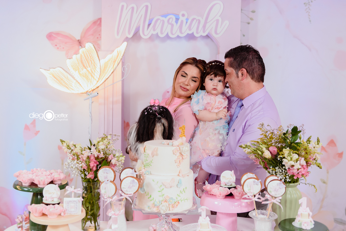 família com cachorro no aniversário na mesa de bolo