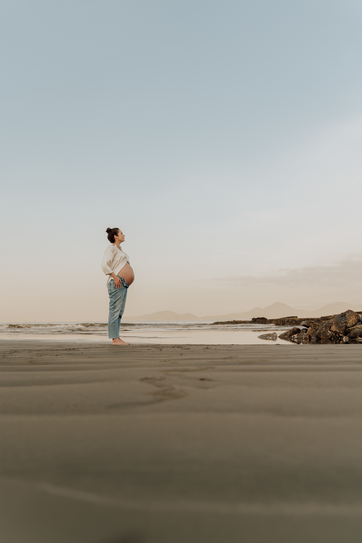 Ensaio fotográfico de grávida na praia de Santos. Registro emocionante e artístico, destacando a conexão com a natureza e a beleza única da gestação. Ideal para quem busca fotografia de grávidas em cenários naturais na Baixada Santista.