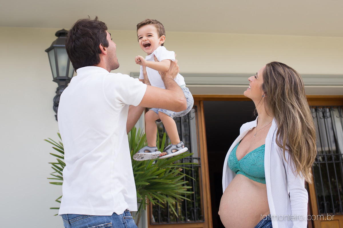 fotografa especializada em gravida sp, pai brincando com bebe no colo e mae olhando