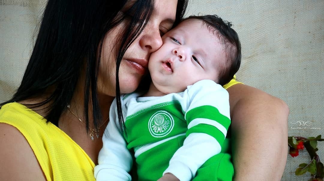 Ensaio fotógrafo Infantil imagem linda a mãe esta com o rosto coladinho com o  seu bebê e ele esta muito foto com o figurino do time do palmeiras fotógrafo Naldo Caitano ensaio fotógrafo estúdio /Santos SP 