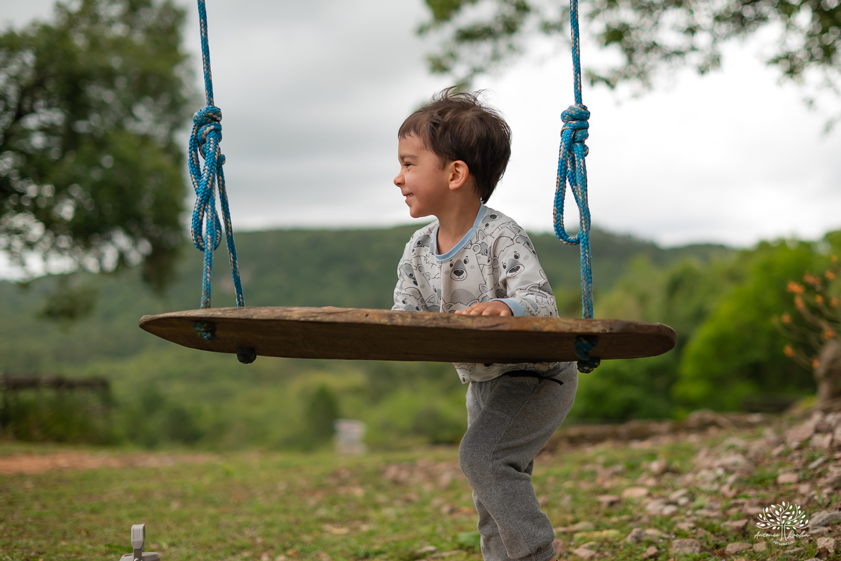 fotografia infantil - primeiro aninho - aniversario intimista - familia - conexao - natureza - pes descalcos - infancia - fotografia documental - aniversario ao ar livre - fogueira em familia - fotografia de familia - celebração simples - cabana - balanço
