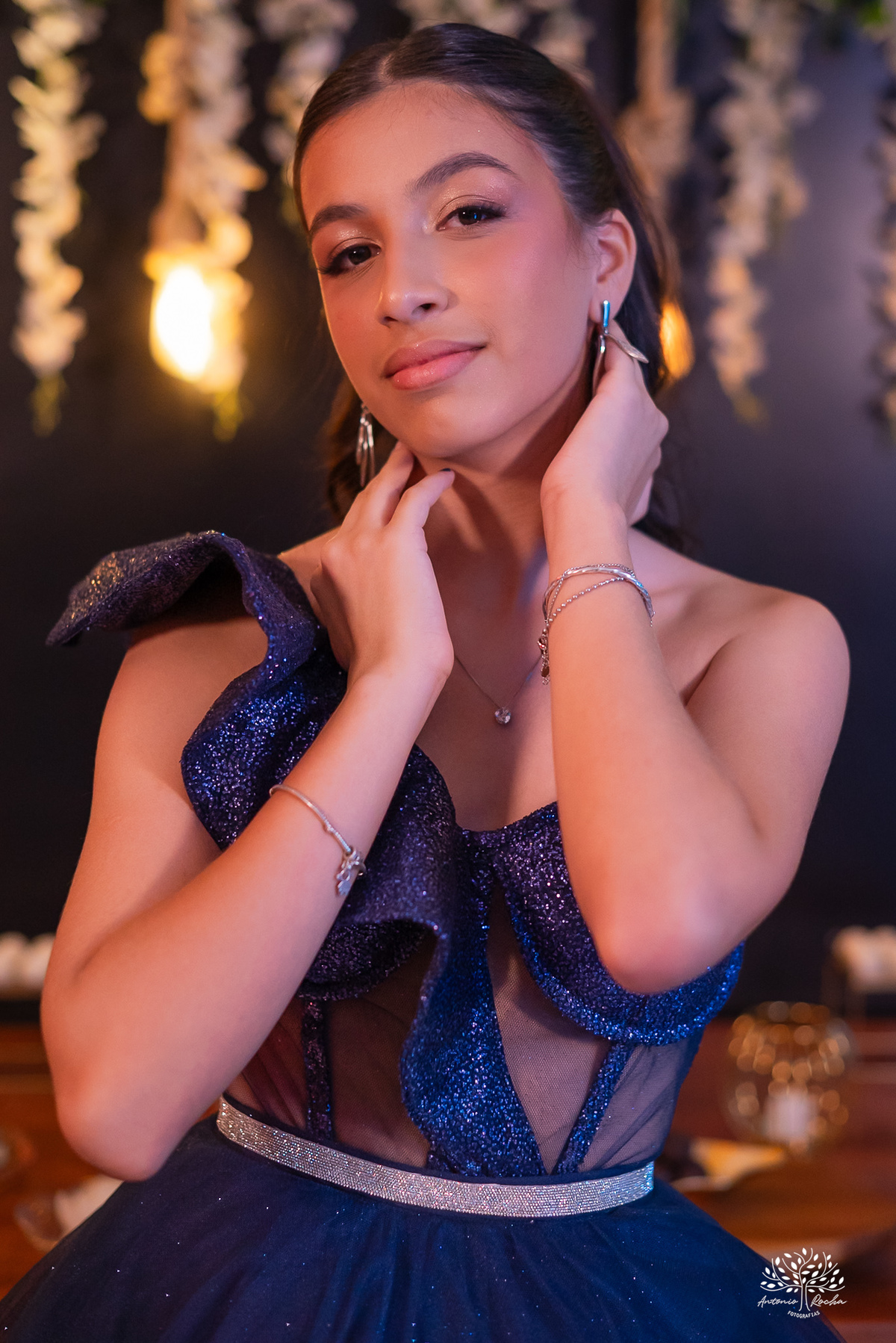 Aniversariante de 15 anos com detalhe delicado do vestido e dos acessórios, revelando elegância e personalidade.