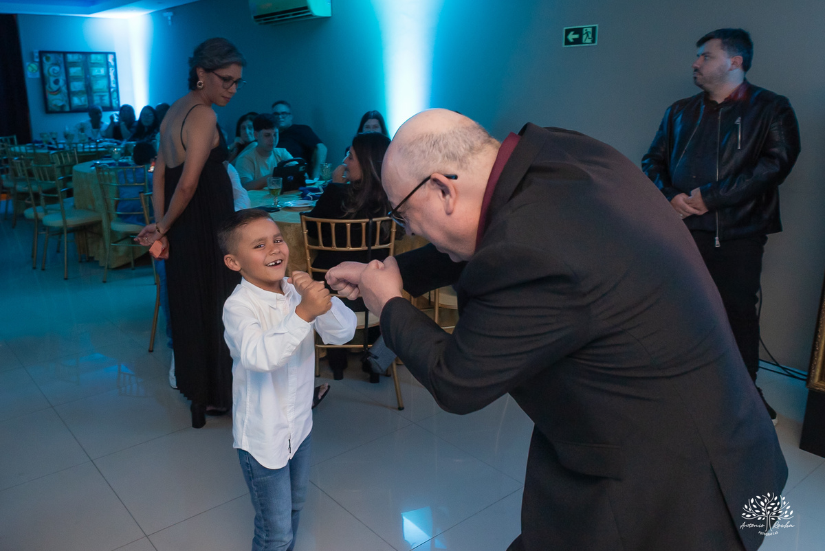 Pai da debutante brincando com convidado mirim