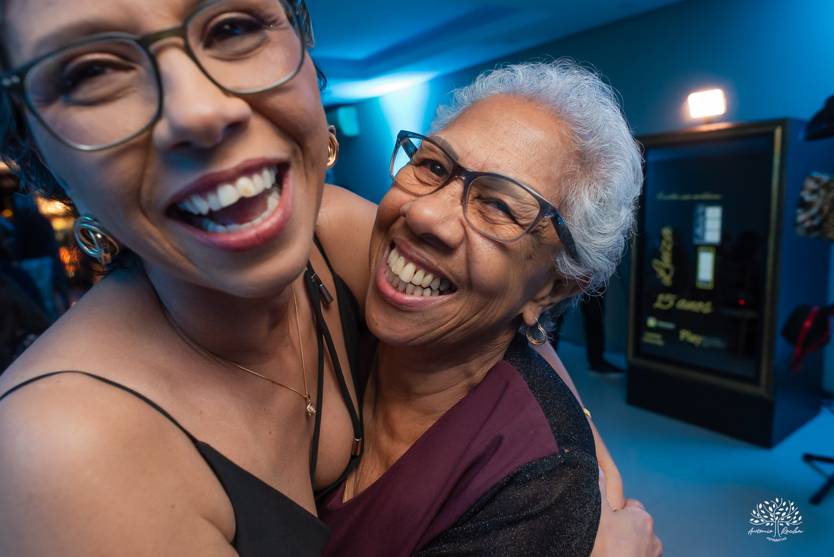 Mãe e avó da debutante com sorriso marcante