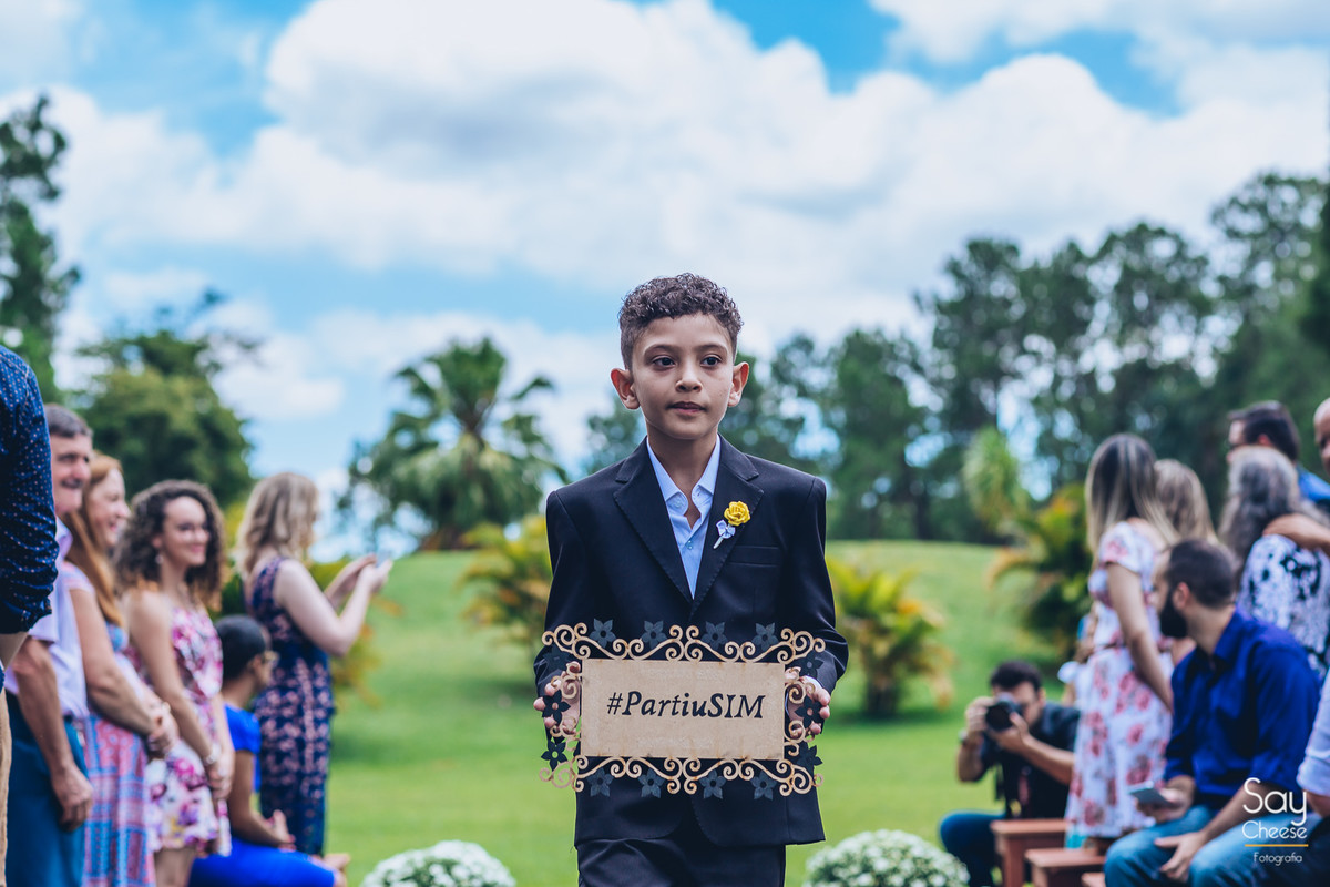 pajem entrando com plaquinha em casamento no campo ao ar livre fotografado por Say Cheese Fotografia