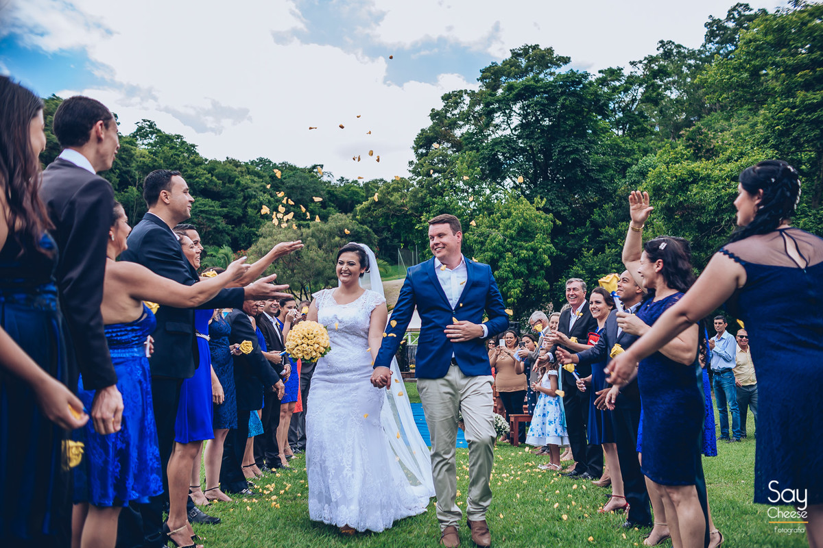 saída dos noivos com chuva de pétalas de flores amarelas em casamento no campo ao ar livre fotografado por Say Cheese Fotografia