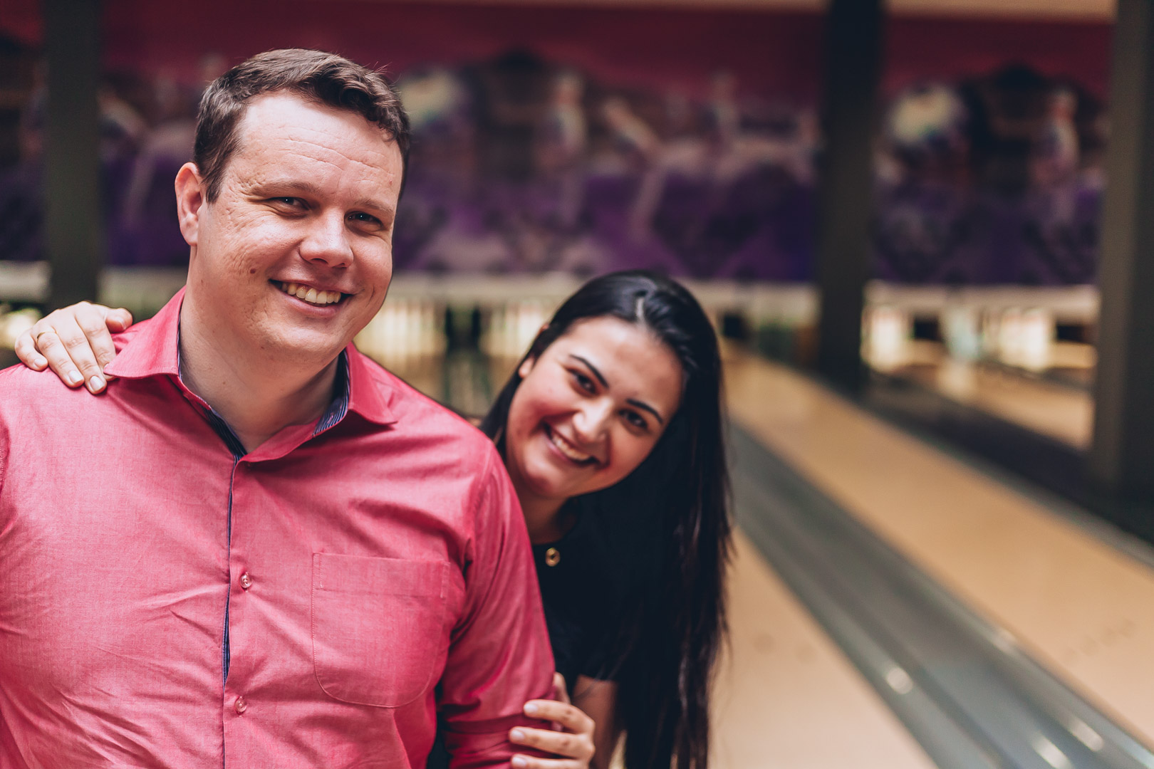 noivos sorrindo em pista de boliche em ensaio pré-wedding fotografado por Say Cheese Fotografia