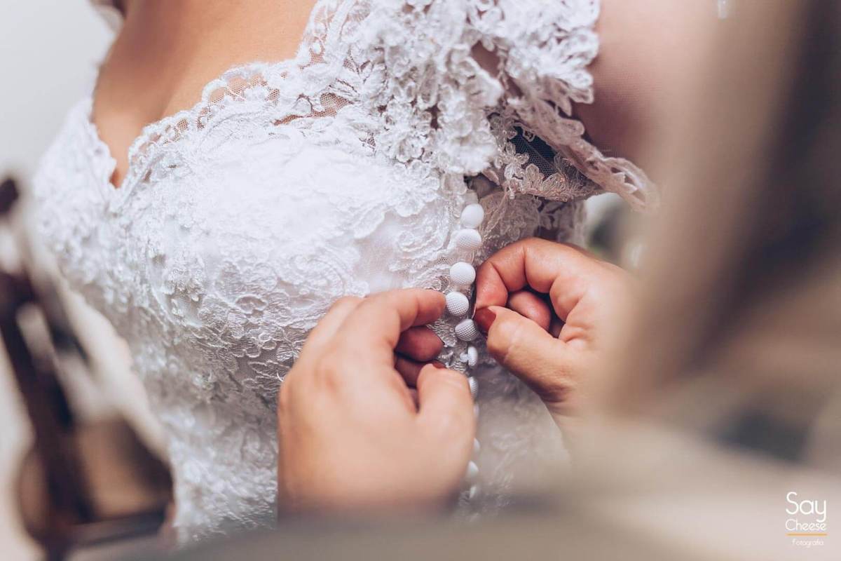 detalhe do vestido de casamento com renda e com botões na lateral