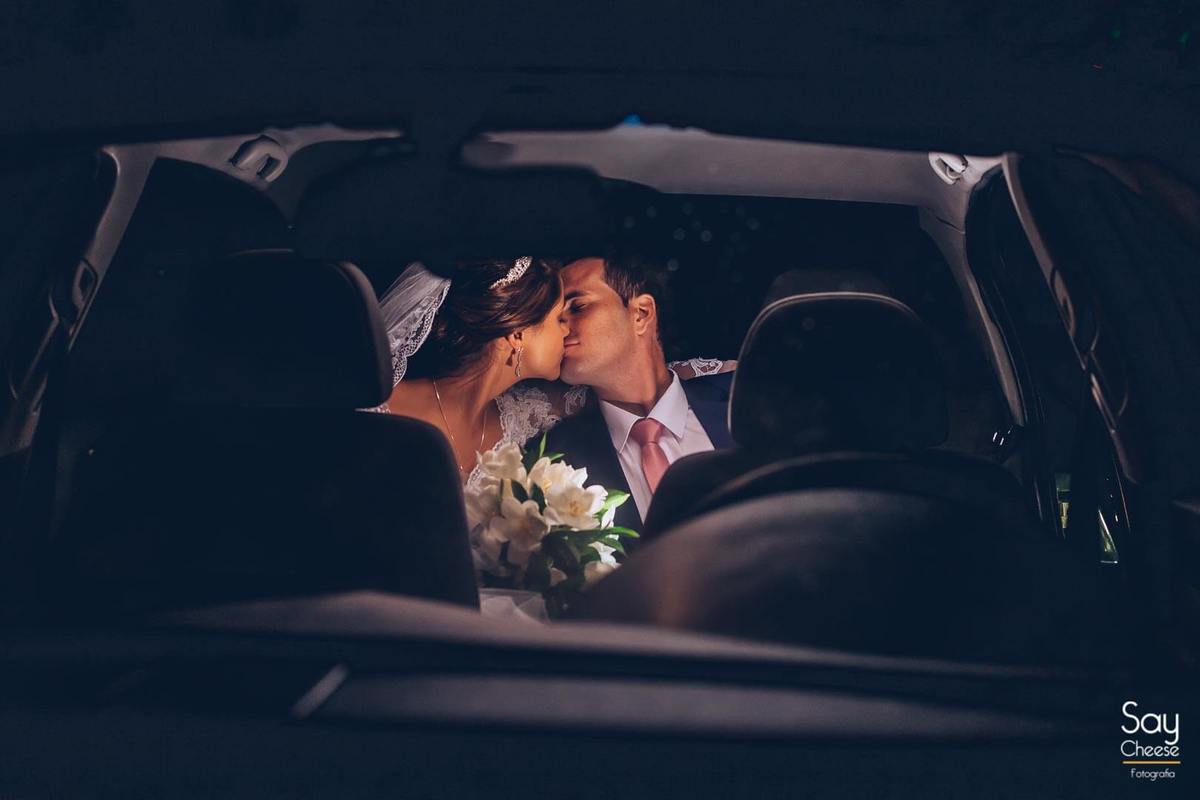 noivos se beijando dentro do carro em ensaio pós-cerimônia