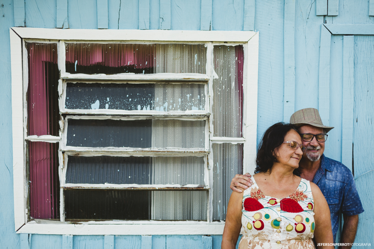 casal de mais idade em ensaio externo em parede de madeira azul no sitio