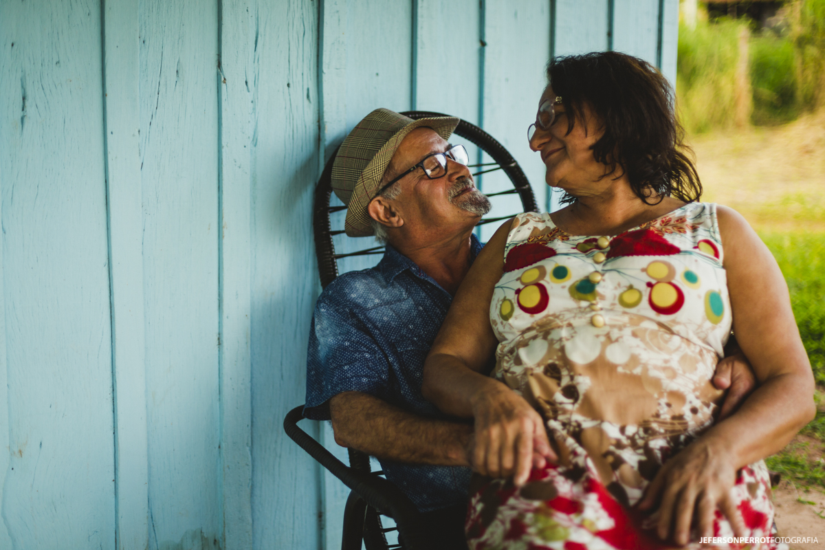 mulher com 60 anos sentada no colo do marido em ensaio externo em mandaguacu