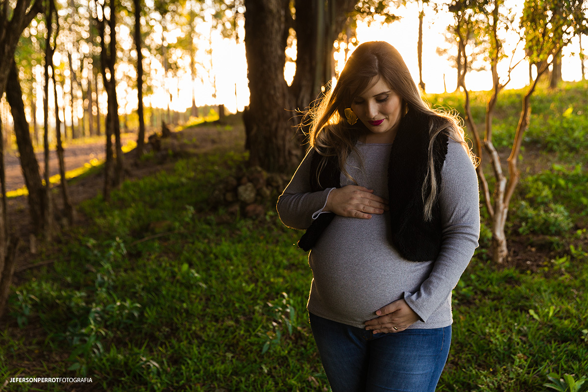 gestante olhando para a barriga na natureza