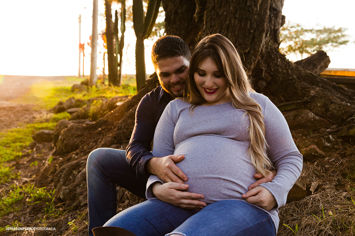 casal gestante sendado e fazendo carinho na futura bebe