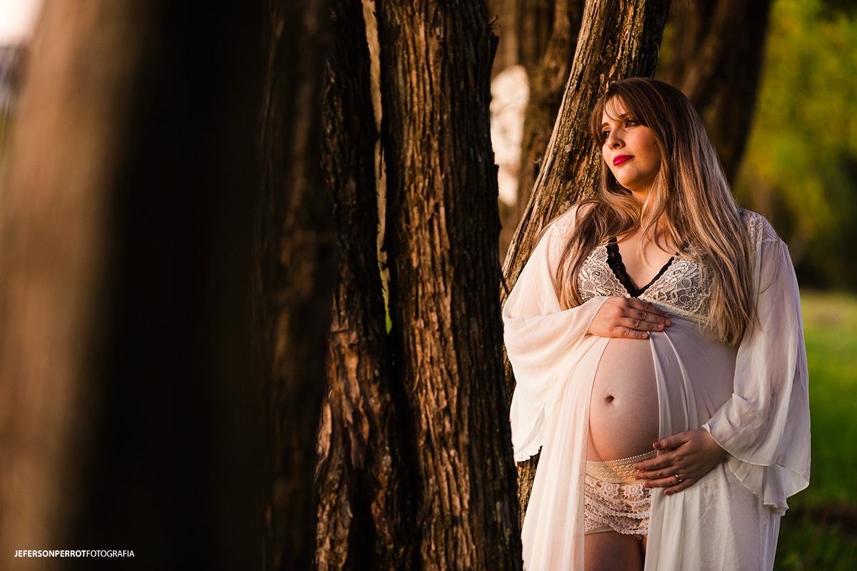 gestante com langerie em meio a arvores
