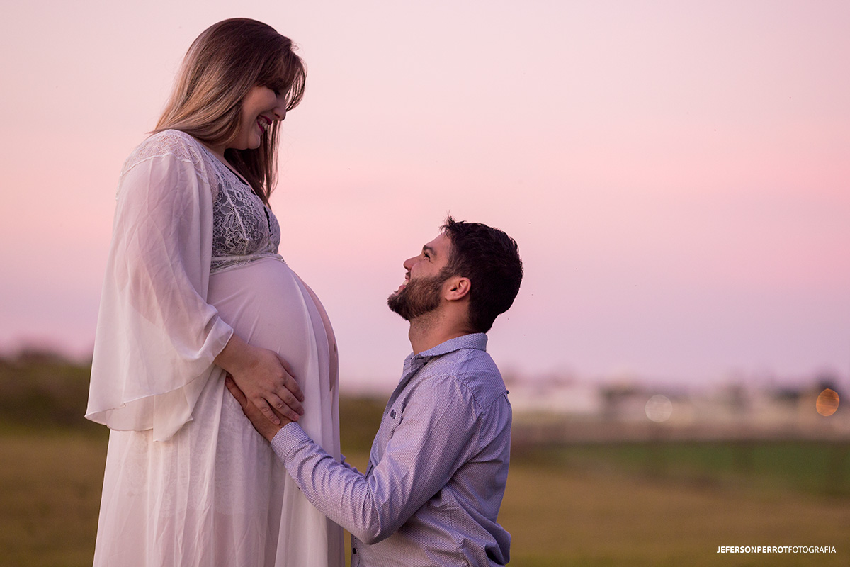 pai ajoelhado olhando para mãe gestante
