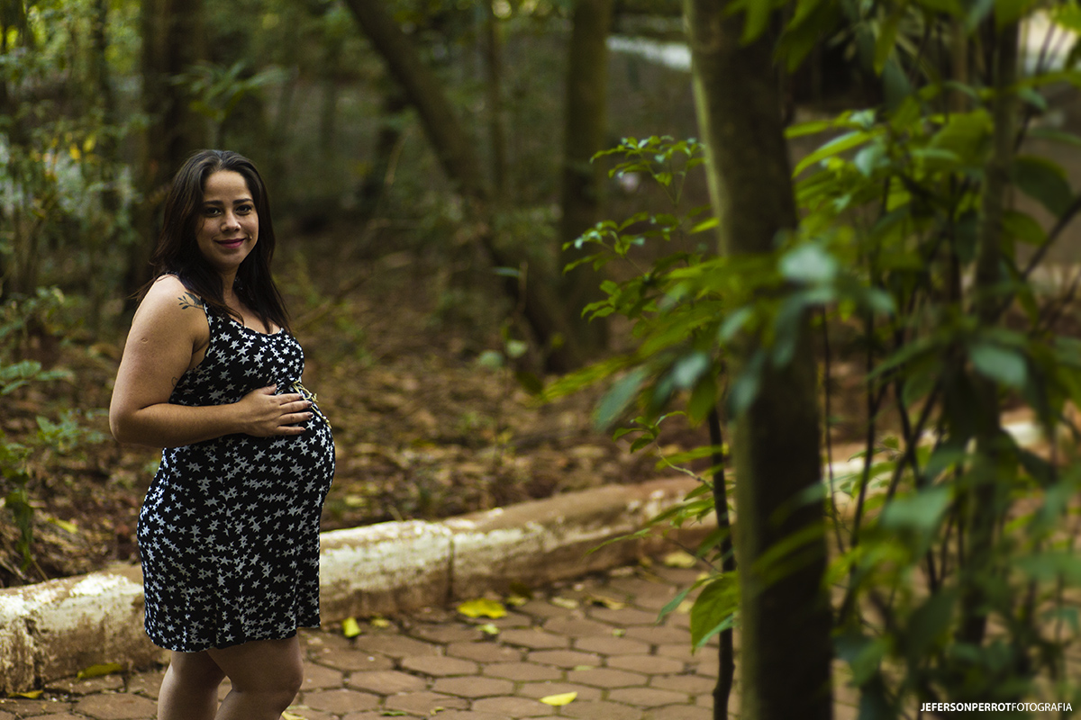 mulher gravida em parque com vestido preto