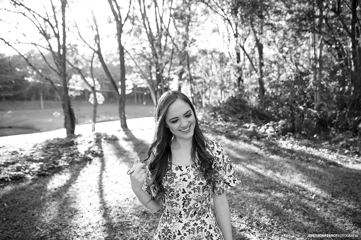 mulher sorridente fotografada em um campo verde de um parque