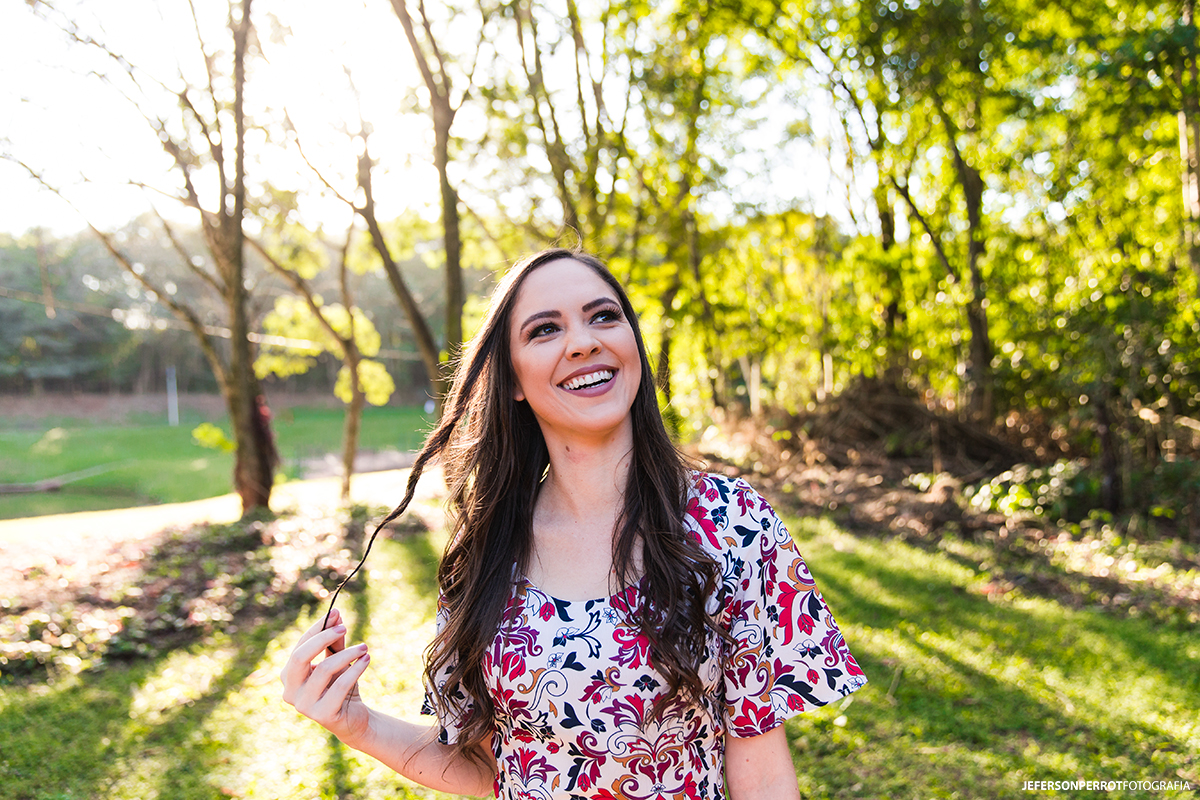 mulher sorrindo em um parque ambiental em meio à vegetação