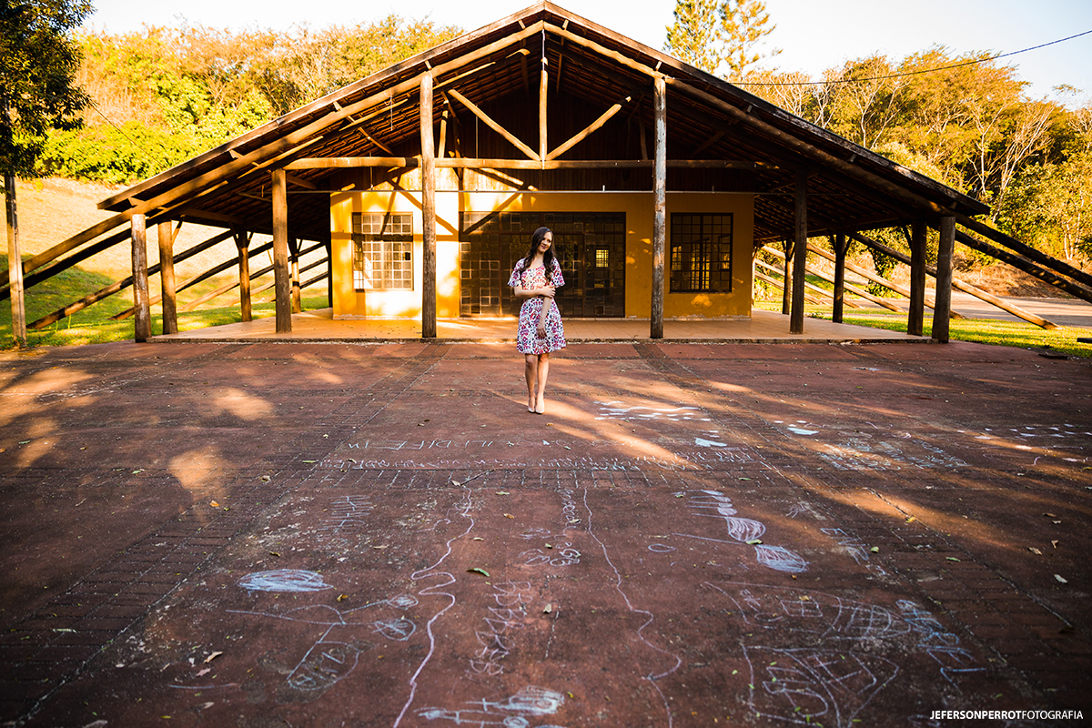 retrato de mulher fotografada em frente a uma construção de um parque