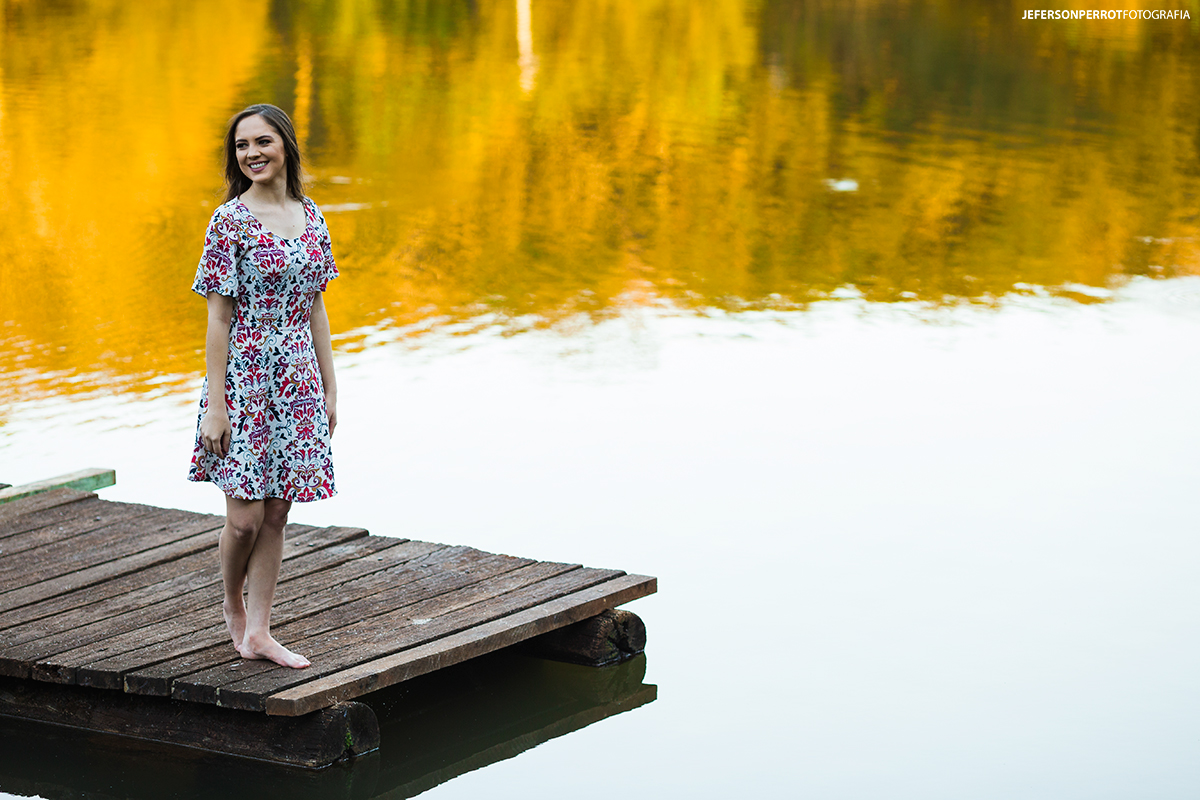 mulher sorridente em um pier de um lago