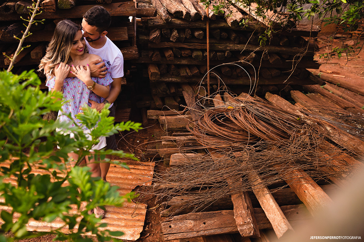 casal abraçado em meio a pedaços de madeira e arame