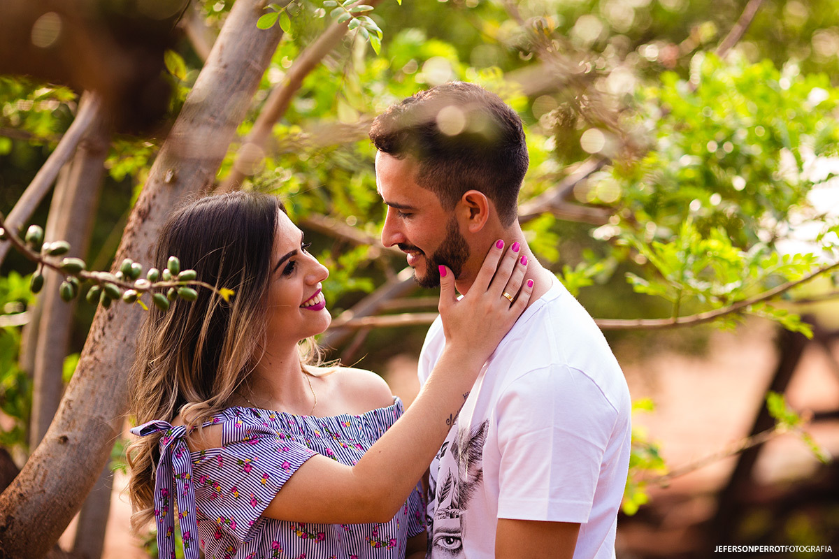 noivos se olhando ao lado de arvore durante ensaio