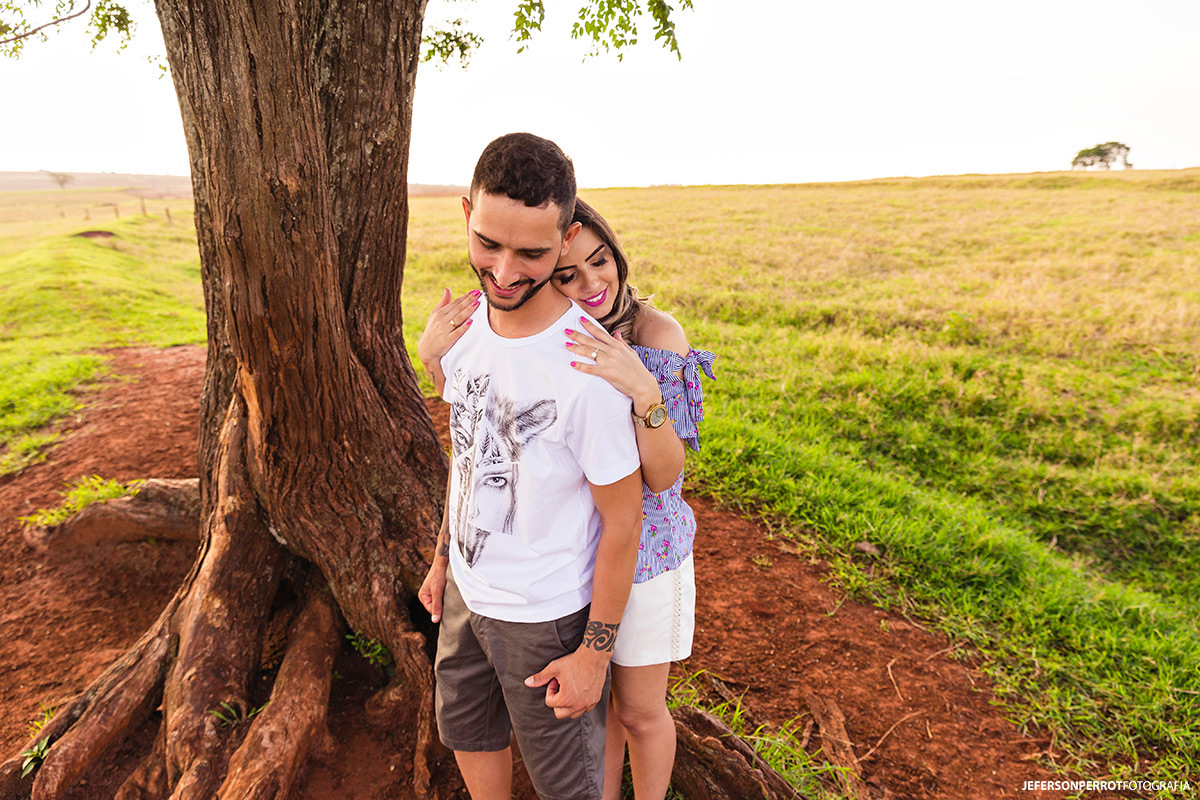 casal na sombra de uma linda árvore em ensaio pre-wedding