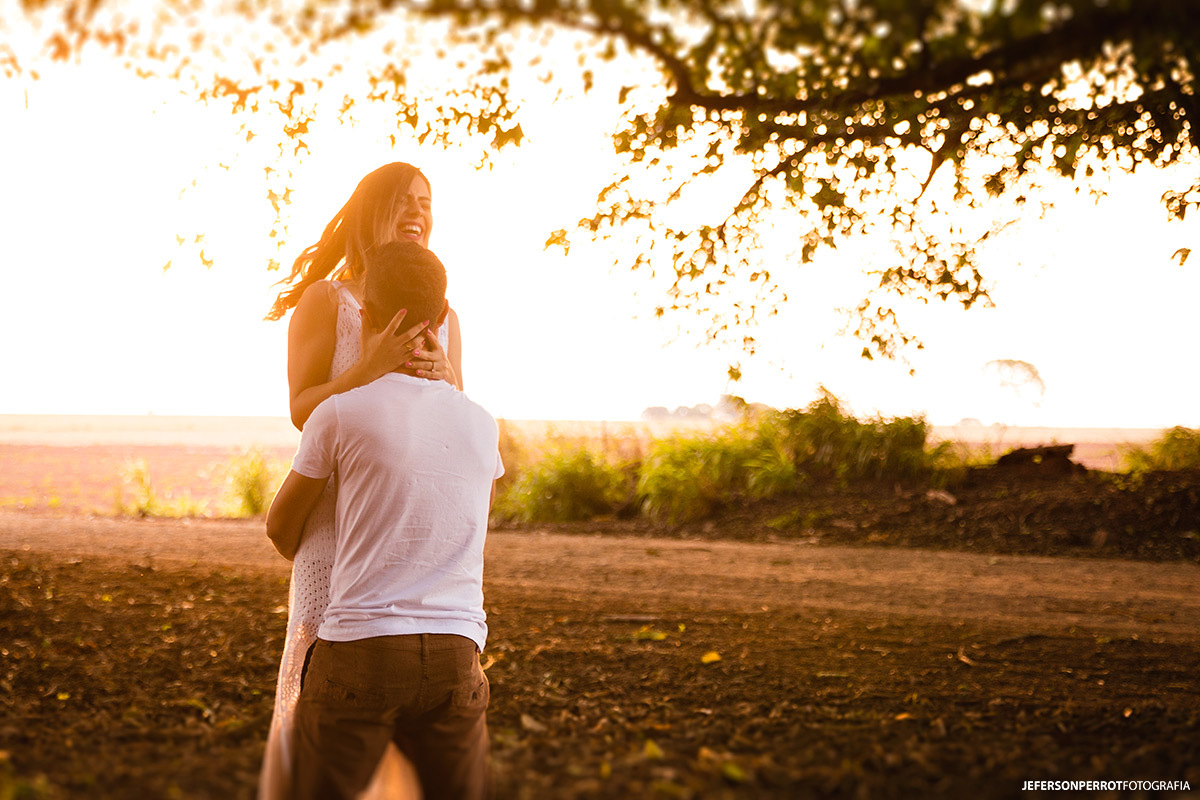 noiva sorrindo amplamente enquanto noivo a gira em ensaio fotográfico pre-casamento