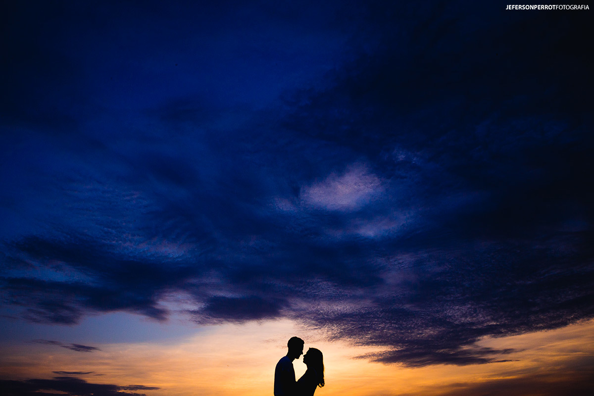 silhueta de casal em por do sol na zona rural de mandaguacu - pr