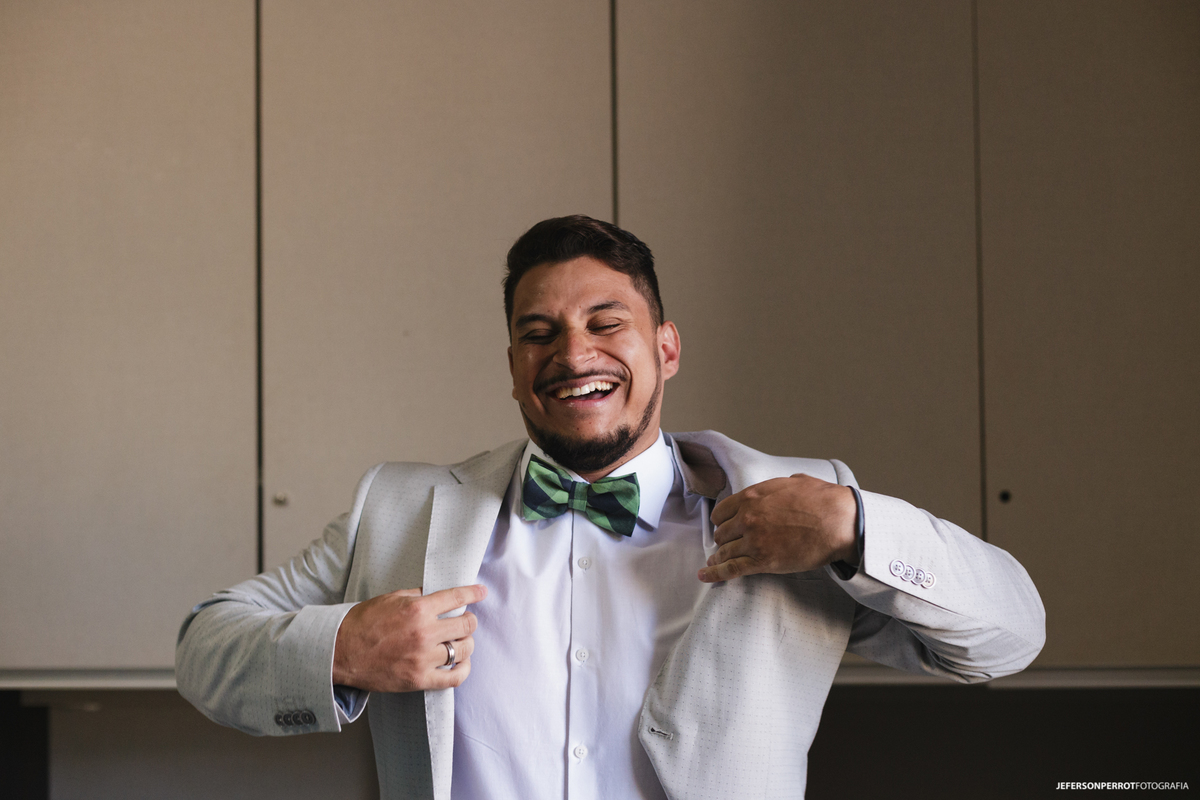 noivo Alisson feliz ao vestir terno