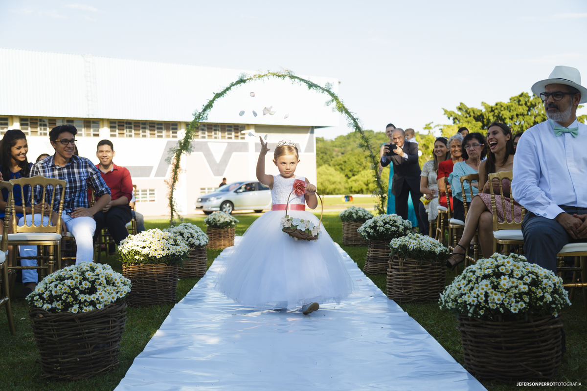 daminha de honra jogando pétalas de rosa em casamento ao ar livre