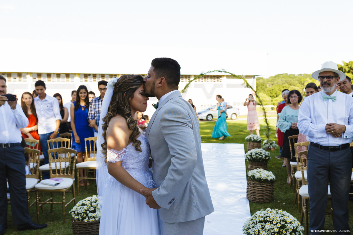 noivo beija a noiva ao recebe-la no altar
