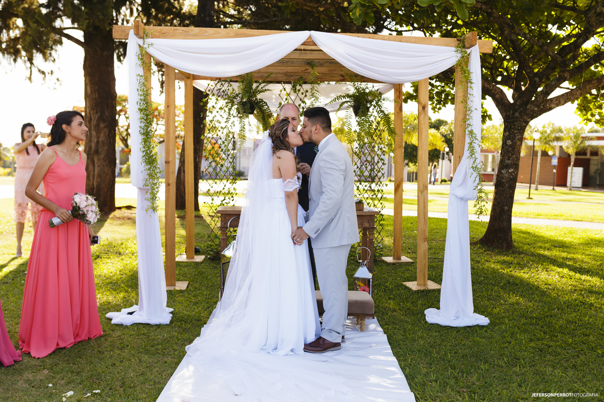 noivos se beijam após trocarem as alianças